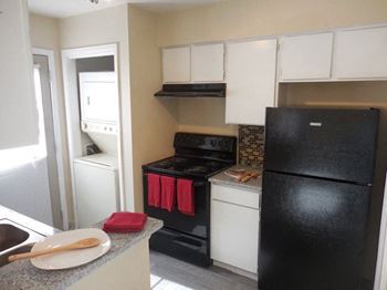 Kitchen with black appliances and white cabinetry